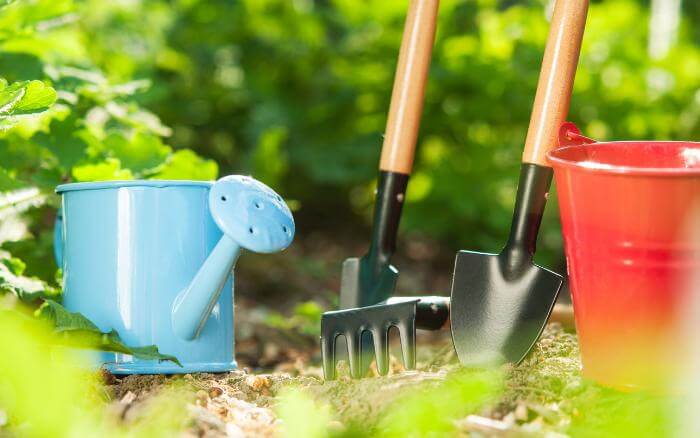 As ferramentas de jardinagem bem conservadas facilitam os cuidados e não danificam as plantas. ferramentas-de-jardinagem-sobre-o-solo-pa-ancinho-e-regador