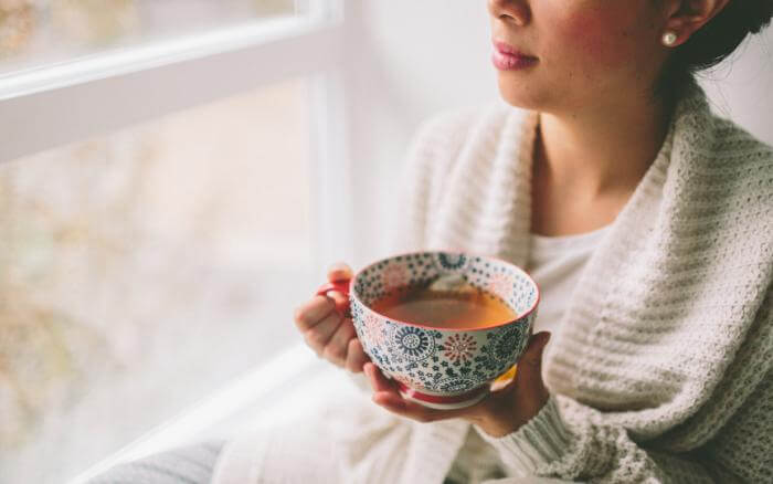 Ervas-que-combatem-os-sintomas-da-TPM Mulher tomando chá.