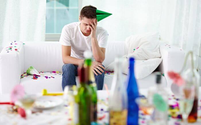 Pessoa-em-ambiente-pos-festa-aparentando-precisar-curar-a-ressaca-rapido